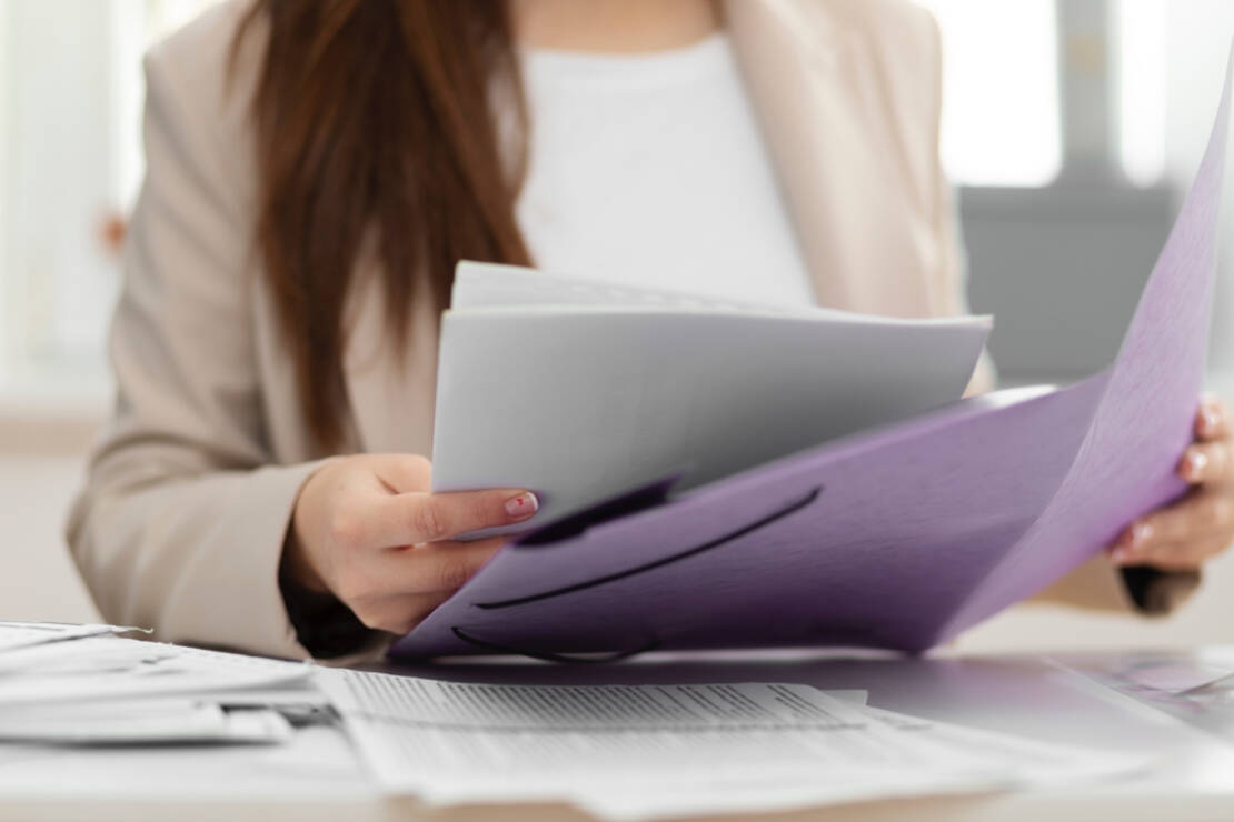 Photo d'une femme portant divers documents administratifs